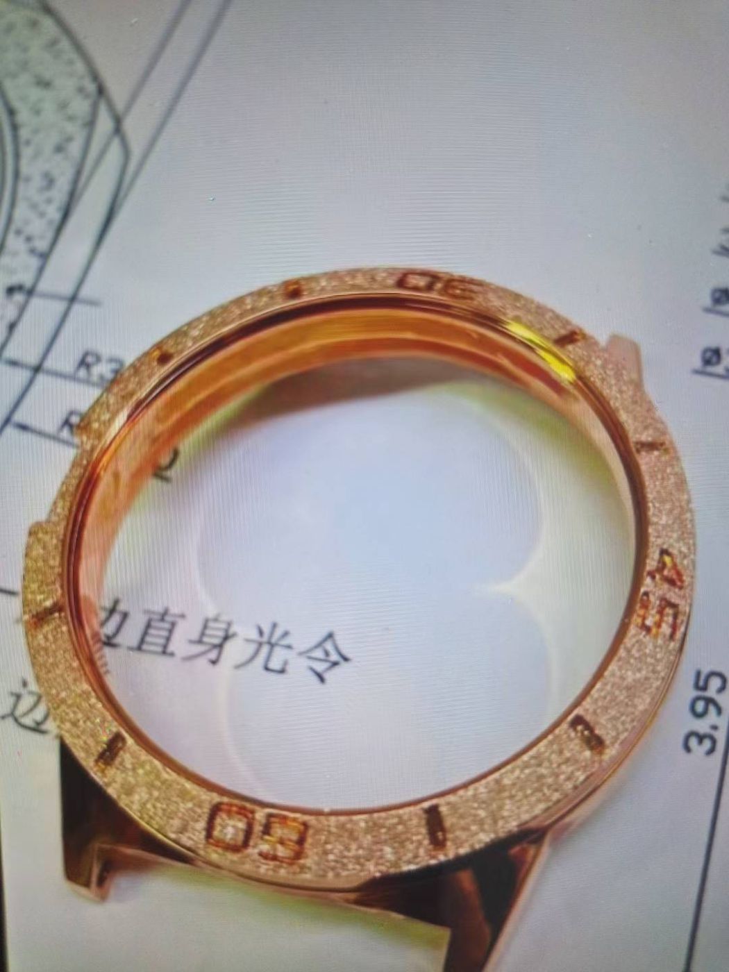 Engraved rose gold bezel placed on its technical drawing